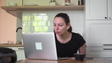 Evde dizüstü bilgisayarı olan genç bir kadın. Haberler, işsizlik e-postası, online dolandırıcılık stresi