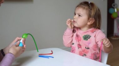 Anne ve çocuk mankenlik balonlarıyla oynuyor. Mutlu kız ve anne evde.