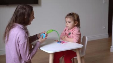 Anne ve çocuk mankenlik balonlarıyla oynuyor. Mutlu kız ve anne evde.