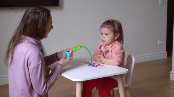 Μητέρα με παιδί που παίζει με μπαλόνια μοντελισμού. Happy κόρη με τη μητέρα στο σπίτι — Αρχείο Βίντεο