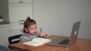 Bebek evde dizüstü bilgisayarla anaokulu e-öğrenimi yapıyor. Çizim. Mutsuz stres. Covid-19 karantina