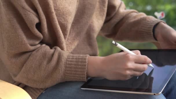 Primer plano de la mujer con tableta y lápiz electrónico que trabaja en el proyecto independiente. Freelancer. Artista independiente — Vídeo de stock