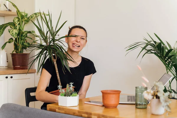 Millennial flicka arbetar hemifrån i ett växtrum. Frilans florist, ung företagare, hem trädgårdsskötsel — Stockfoto