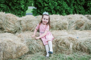 Küçük kız saman üzerinde oynanır