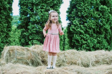 Küçük kız saman üzerinde oynanır