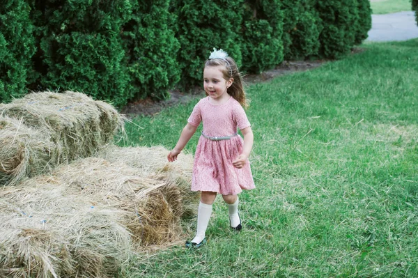 Menina é jogado no feno — Fotografia de Stock