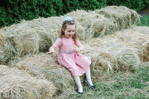 Küçük kız saman üzerinde oynanır — Stok fotoğraf