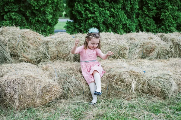 Küçük kız saman üzerinde oynanır — Stok fotoğraf