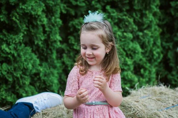 Little girl is played on the hay — Stock Photo, Image