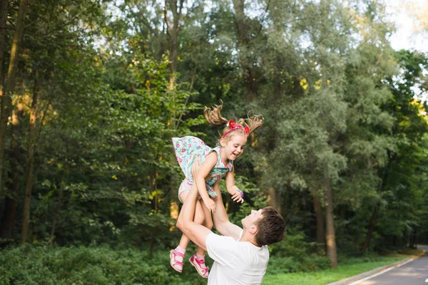 Father throws his daughter. Parents play with their daughter, Dad and Daughter. — Stock Photo, Image