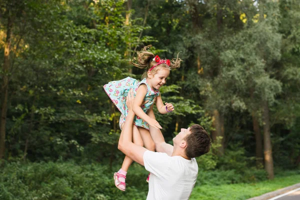 Father throws his daughter. Parents play with their daughter, Dad and Daughter. — Stock Photo, Image