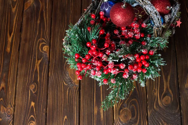 Neujahrsspielzeug in einem Korb auf einem hölzernen Hintergrund. Weihnachtsspielzeug. — Stockfoto