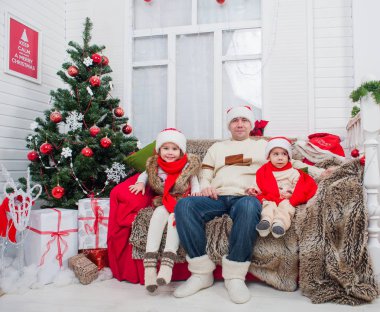 Noel aile - baba ile oğlu ve kızı. Noel ve yeni yıl hediye ve bir Noel ağacı ile bir iç Oda süslemeleri