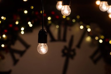 Noel ağacı ve hediyelerle süslenmiş güzel bir oturma odası. Ahşap duvarda büyük sihirli bir saat. Kış tatili tasarımı ve dekorasyon geçmişi.