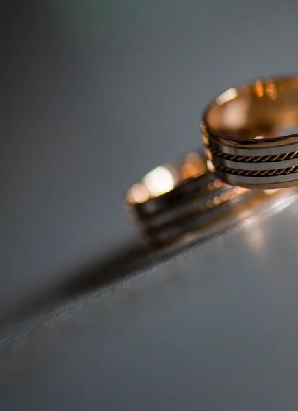 Anillo de boda de diamantes de mujer como se ve a través de la banda de oro de un hombre — Foto de Stock