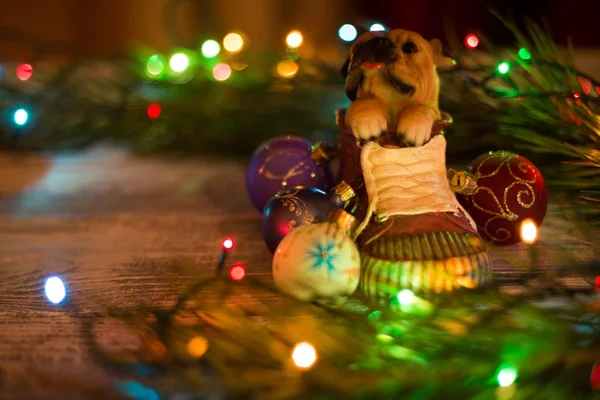 Weihnachtsdekoration, Kugeln, Lichter, Spielzeug, Hündchen, Girlanden und Kiefern auf einem flachen Holzgrund liegend. — Stockfoto