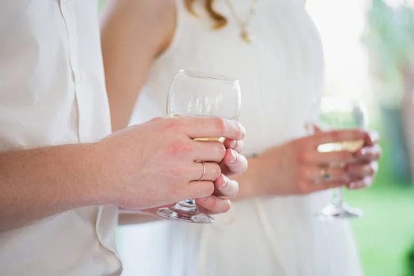 Handen van de pasgetrouwden met een glas — Stockfoto