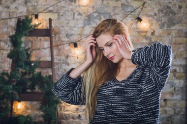 Kadın modeli ve tuğla taş. Güzel kız, uzun kızıl saçlı. Bir merdiven, bir tuğla duvar önünde duran bir kadın