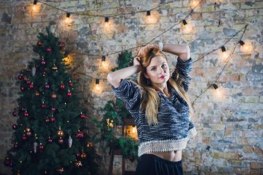 Kadın modeli ve tuğla taş. Güzel kız, uzun kızıl saçlı. Bir merdiven, bir tuğla duvar önünde duran bir kadın