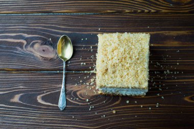 Lezzetli çocuk oyuncağı ahşap bir masa üzerinde bir kaşıkla. Bir pasta ile ahşap bir masa üzerinde kırıntısı.