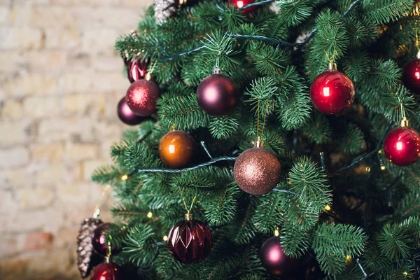 Weihnachtsbaum mit Girlanden auf Backsteinmauer Hintergrund — Stockfoto