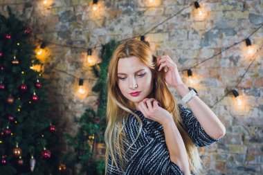 Kadın modeli ve tuğla taş. Güzel kız, uzun kızıl saçlı. Yakın çekim, kadın portre