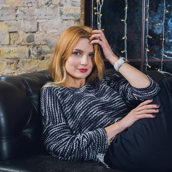 Kadın modeli ve tuğla taş. Güzel kız, uzun kızıl saçlı. Yakın çekim, kadın portre