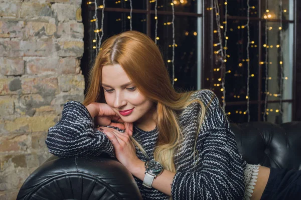 Kadın modeli ve tuğla taş. Güzel kız, uzun kızıl saçlı. Yakın çekim, kadın portre