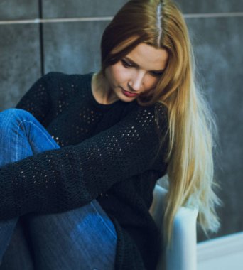 Kadın modeli ve tuğla taş. Güzel kız, uzun kızıl saçlı. Yakın çekim, kadın portre