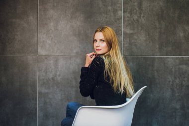 Kadın modeli ve tuğla taş. Güzel kız, uzun kızıl saçlı. Yakın çekim, kadın portre