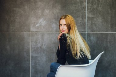 Kadın modeli ve tuğla taş. Güzel kız, uzun kızıl saçlı. Yakın çekim, kadın portre