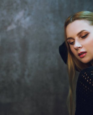 Kızıl saçlı kız Studio gri bir arka plan üzerinde poz. Stüdyoda genç modeli