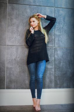 Kızıl saçlı kız Studio gri bir arka plan üzerinde poz. Stüdyoda genç modeli