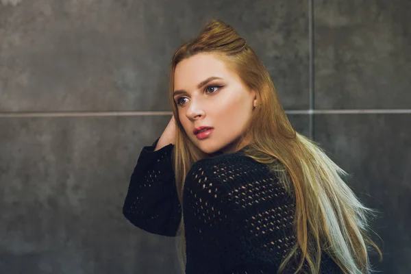 Kızıl saçlı kız Studio gri bir arka plan üzerinde poz. Stüdyoda genç modeli