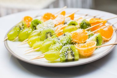 Portakal, kivi ve üzüm şiş üzerinde arka plan ışık. ? kaybetmek-yukarıya-in meyve.