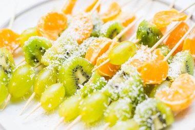 Portakal, kivi ve üzüm şiş üzerinde arka plan ışık. ? kaybetmek-yukarıya-in meyve.