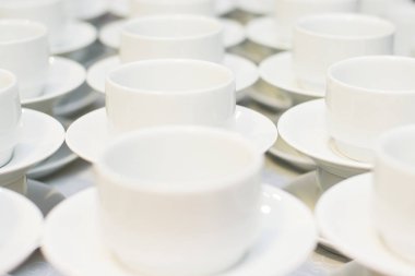 Beyaz kahve fincanı tabağı ve tabloda çay kaşığı ile birçok satır