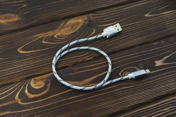Charging wire on a wooden table — Stock Photo, Image