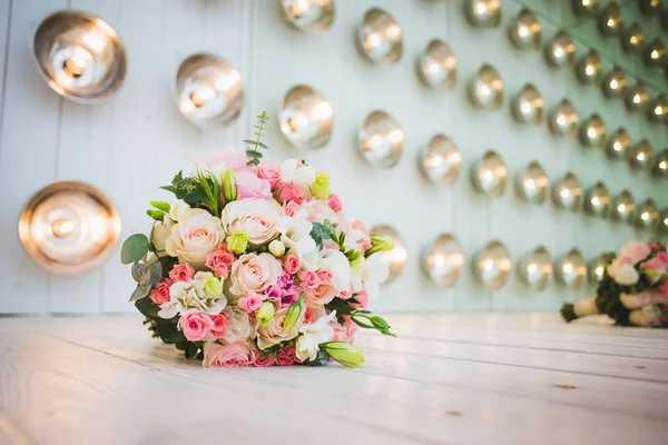 A luxurious wedding bouquet, with fresh roses in studio decorations, amid a series of light bulbs. Place for your text. — Stock Photo, Image