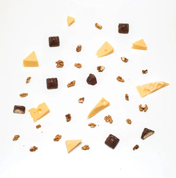 Işık kağıt arka plan üzerinde Yunan fındık ile peynir parçalarını. çikolata şeker