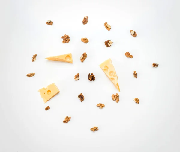 Trozos de queso con nueces griegas sobre un fondo de papel ligero Imagen de archivo