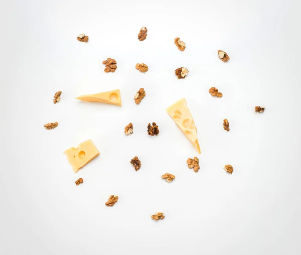 Trozos de queso con nueces griegas sobre un fondo de papel ligero Imagen de stock