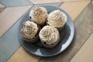 dört kek tabakta, üstten görünüm. Çikolata ile beyaz beze.