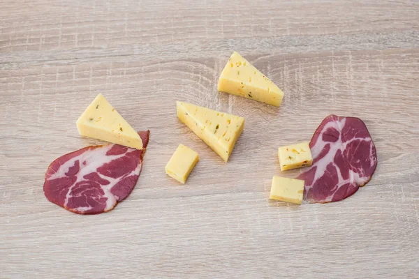 Three slices of cheese with meat on a wooden background — Stock Photo, Image