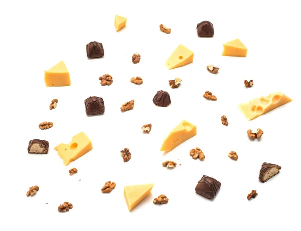 Pieces of cheese with Greek nuts on a light paper background. chocolate candy — Stock Photo, Image