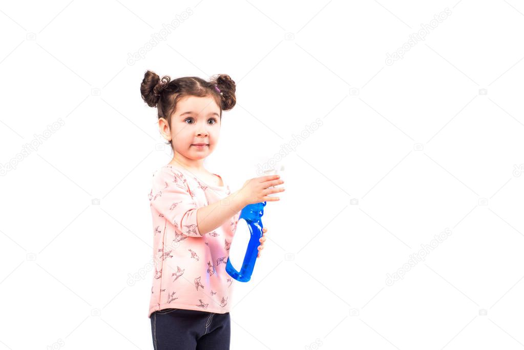 Little girl washes the window. The children clean the house. Children help at home. Toddler cleaning the window and door on a light background.
