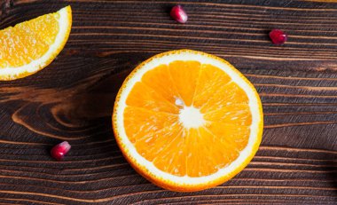 Koyu ahşap arka plan portakal ve nar dilimleri. Metin için yer. Flatlay