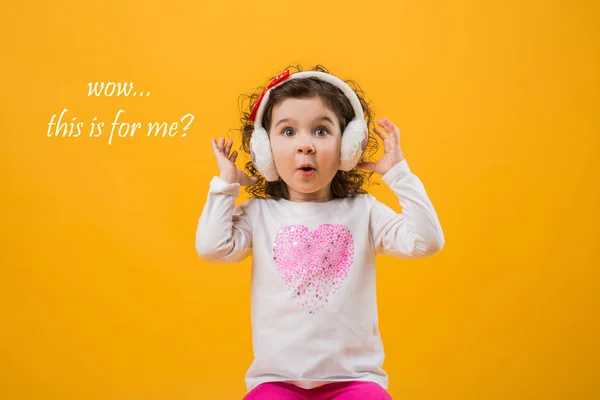 Niña con auriculares sobre fondo amarillo —  Fotos de Stock