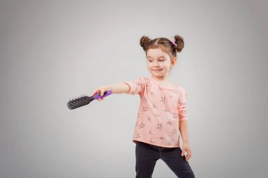 Çocuk hafif bir arka plan üzerinde bir tarak ile