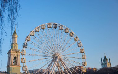 Kiev 'de dönme dolabı, etek ucu. Tüm aile için bir eğlence bölgesi, kilisenin arka planda bir dönme dolabı.